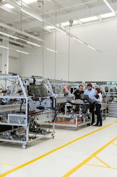 Team of engineers discussing projects in a high-tech factory setting.