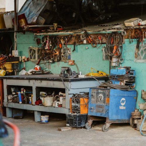 A cluttered workshop with tools, welding equipment, and storage solutions.